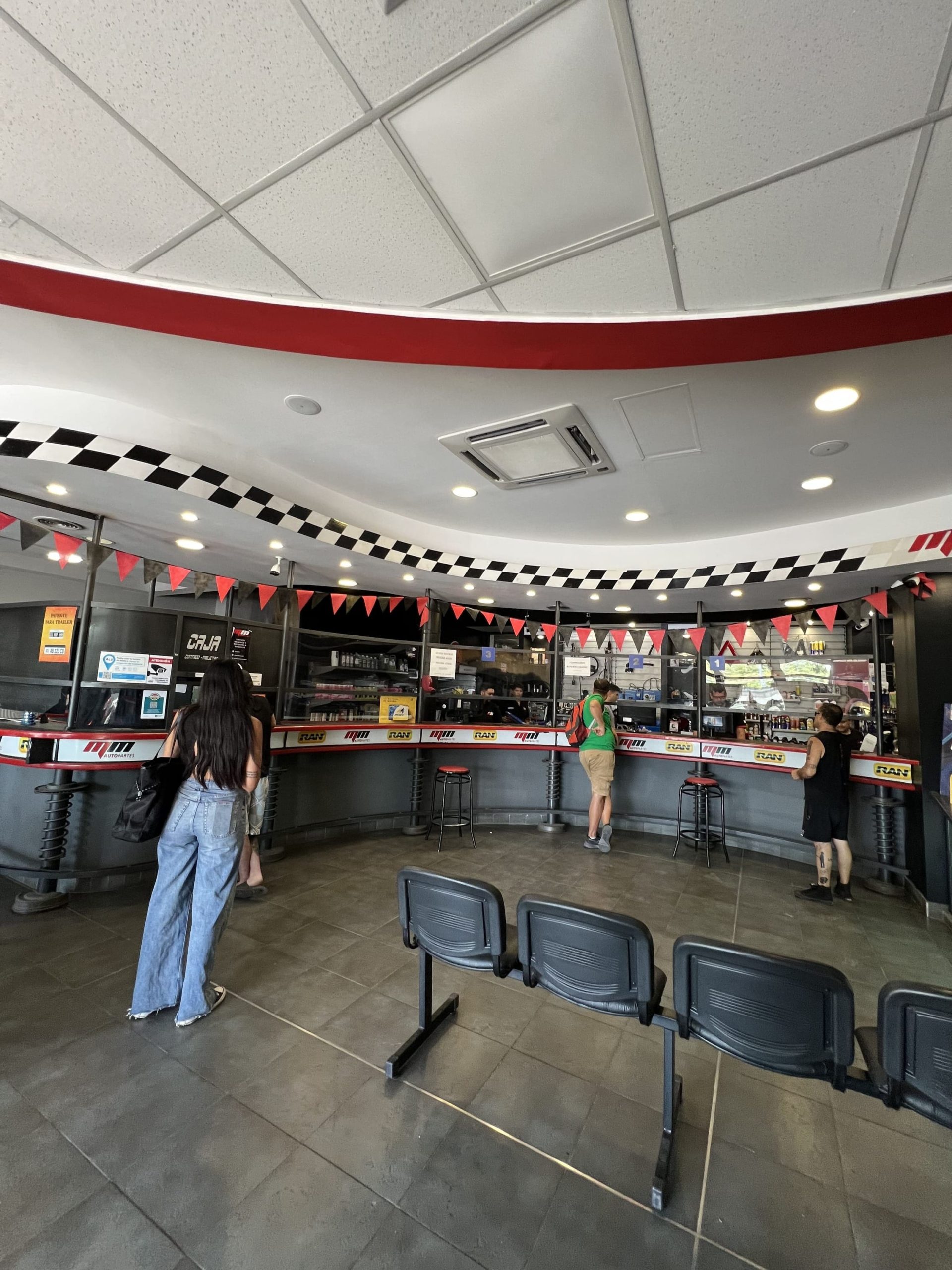 Interior del local de MM Repuestos con clientes en el mostrador, Costanera Mendoza